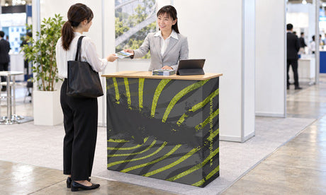 展示会のレンタルカウンターで来場者に資料を渡す受付の使用イメージ｜レンタル1番ドットコム